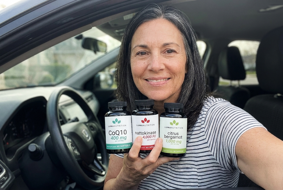 Woman in her 50s in her car holding the Luma Nutrition Heart Health Bundle — CoQ10, Nattokinase, Citrus Bergamot
