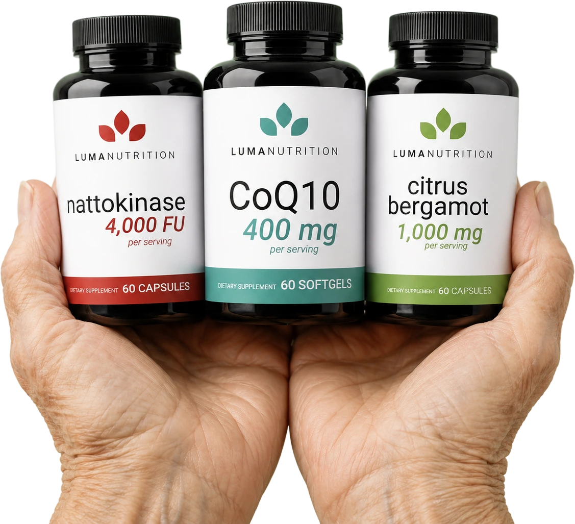 Two hands holding the three Luma Heart Health Protocol bottles: nattokinase, CoQ10 and citrus bergamot