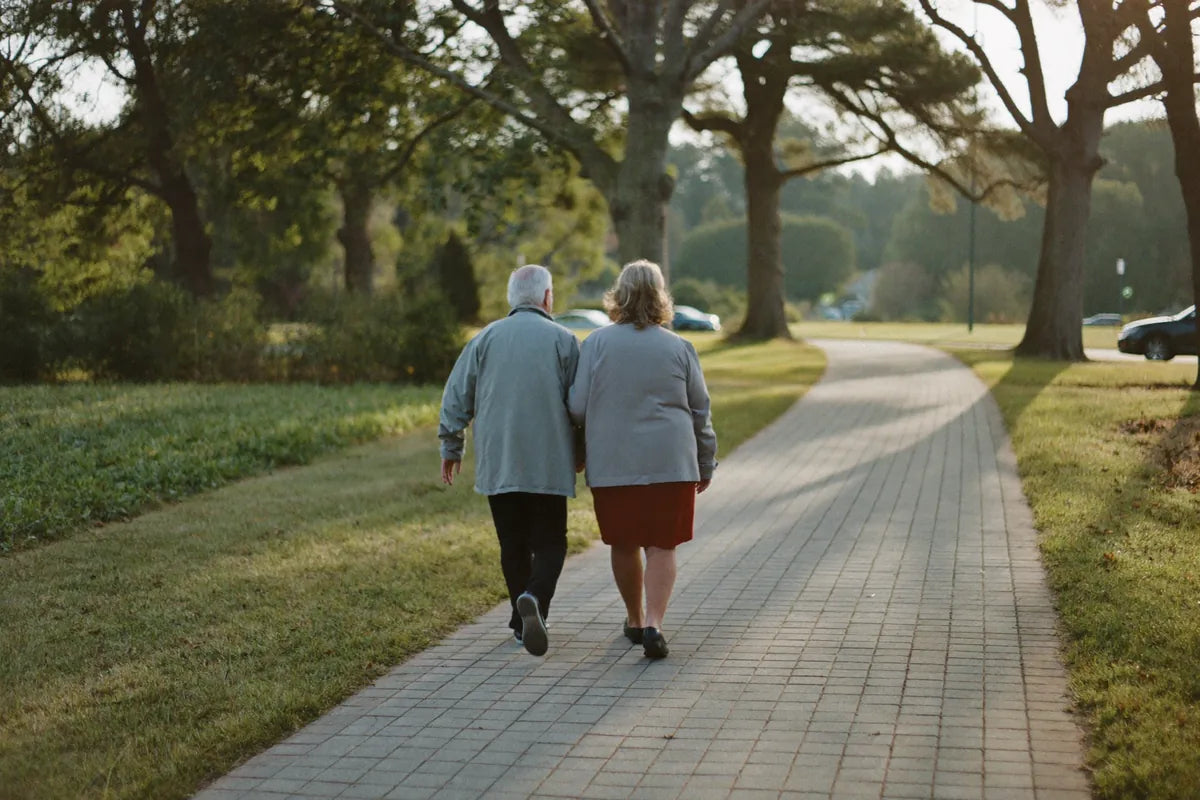 An older couple walking a neighbourhood path